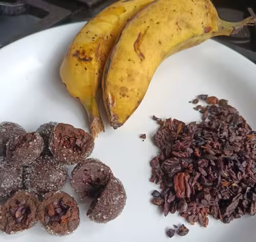 Bananas maduras, doces de banana com cacau e nibs de cacau sobre um prato branco