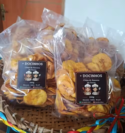 Pacotes de chips artesanais de banana da terra da Mais Docinhos em uma cesta